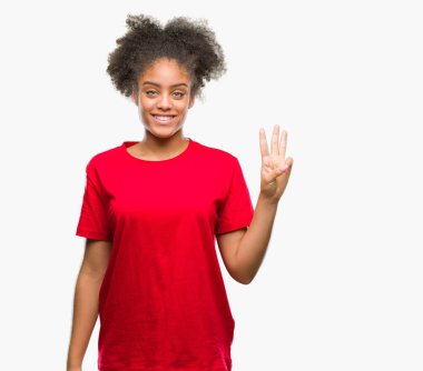 Genç afro Amerikalı kadın gösterilen ve parmakları ile işaret izole arka plan üzerinde üçüncü ise kendinden emin ve mutlu gülümseyerek.