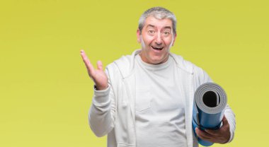 Yoga mat holding yakışıklı komuta sizde büyük gülümseme ile çığlık zaferini kutluyor ve ellerini kaldırdı arka plan çok mutlu ve heyecanlı, kazanan ifade izole