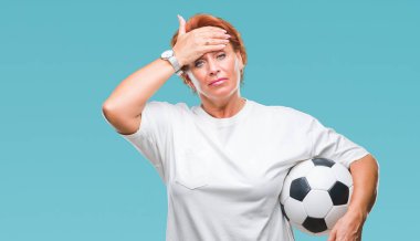 Futbol topu kafa üzerinde el ile vurguladı izole arka plan üzerinde tutan Atrractive üst düzey beyaz Kızıl saçlı kadın şok utanç ve sürpriz suratla, öfkeli ve sinirli. Korku ve hata için üzgün.