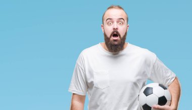Futbol futbol topu izole arka plan üzerinde bir sürpriz yüz, korkuyor ve heyecanlı korku ifadesi ile şok korkmuş tutan genç beyaz hipster adam