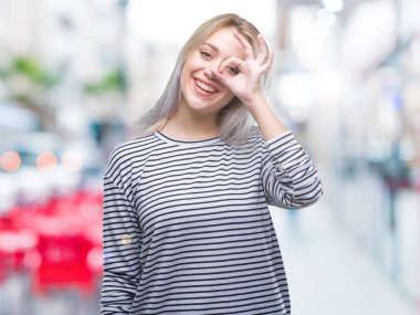 Sarışın genç kadın gülümsüyor, parmakları ile mutlu yüz üzerinden seyir göz el ile ok jest yapıyor izole arka plan üzerinde.