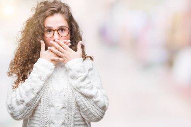 Güzel esmer kıvırcık saçlı Genç kız izole arka plan ağız hata için elleriyle kapsayan şok üzerinde kış kazak giyiyor. Gizli kavramı.