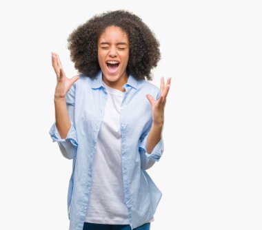 Genç afro Amerikalı kadın deli ve silah ile başarı için deli kutluyor izole arka plan üzerinde kaldırdı ve heyecanlı çığlık gözler kapalı. Kazanan kavramı