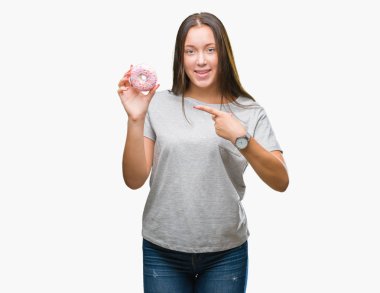 İzole arka el ve parmak ile işaret çok mutlu üzerinde tatlı çörek yiyen genç kafkas kadın