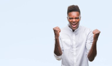 İzole arka plan kutlama üzerinde genç Afro-Amerikan adam şaşırttı ve başarı için kaldırdı kollarını açarak hayret ve gözleri açık. Kazanan kavramı.