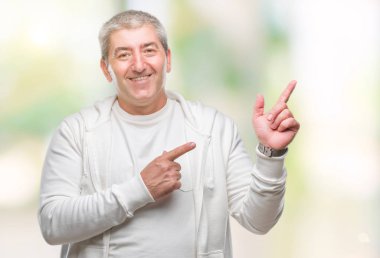 Üst düzey yakışıklı gülümseyen ve iki elleri ve parmakları ile tarafına işaret kamera bakarak izole arka plan üzerinde spor giyim eşyası.