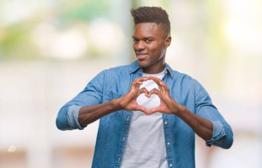 Afrikalı-Amerikalı genç aşık kalp simgesi ve elleriyle şekil gösteren gülümseyen izole arka plan üzerinde. Romantik kavramı.