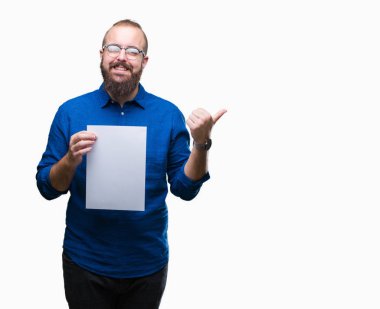 Gözlük takan ve işaret ve başparmak kadar mutlu yüz gülümseyen tarafı ile gösteren izole arka plan üzerinde boş kağıt tutan genç hipster adam