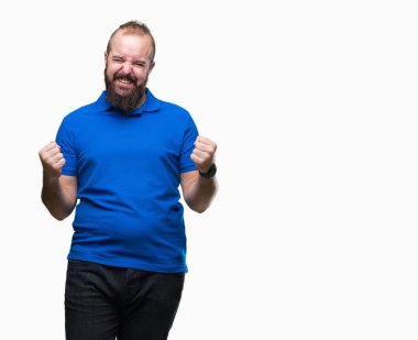 Üzerinde mavi gömlek giymiş genç beyaz hipster adam arka plan çok mutlu ve heyecanlı kaldırdı, silah ile kazanan jest yapıyor gülümseyen ve başarı için çığlık izole. Kutlama kavramı.