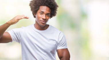 Afro Amerikalı adam izole arka plan ile büyük ve büyük boy işaret, ölçü birimi sembol gösteren el eller üzerinde. Kameraya bakarak gülümsüyordu. Ölçüm kavramı.