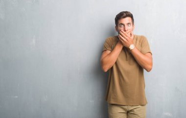 Gri grunge duvar eller için hata ile ağız kapsayan şok yakışıklı genç adam. Gizli kavramı.