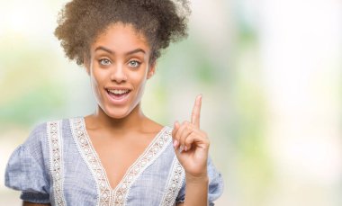Başarılı fikirle parmağı yukarıyı izole arka plan üzerinde genç afro Amerikalı kadın. Çıktıktan ve mutlu. Bir numara.