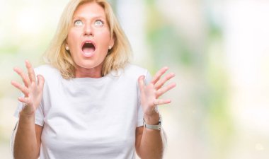 Orta yaş sarışın kadın izole arka plan çılgın ve kızgın bağırarak ve agresif ifade ve silah kaldırdı bağırıyor. Hayal kırıklığı kavramı.