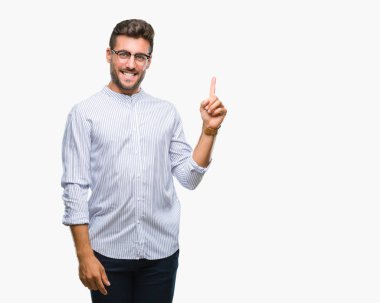 Kameraya bakarak yan el ve parmak ile işaret eden genç yakışıklı adam yüzünde kocaman bir gülümseme ile izole arka plan üzerinde.