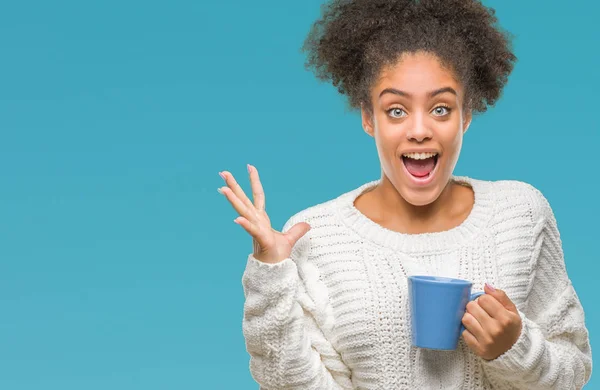 Young afro american woman driking cup of coffee over isolated background very happy and excited, winner expression celebrating victory screaming with big smile and raised hands