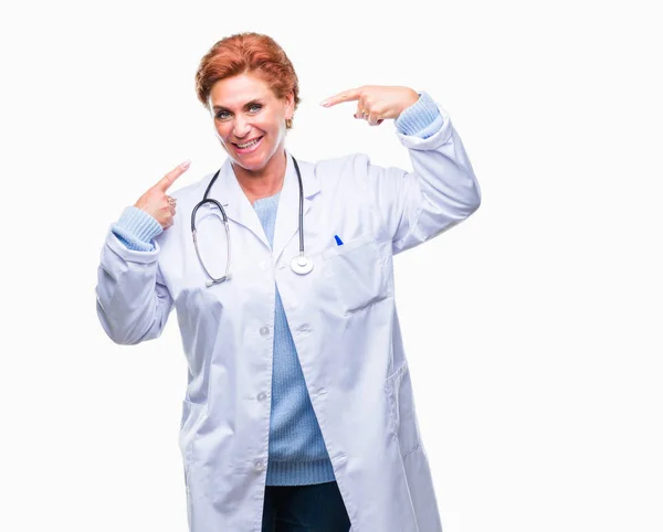 高级白种人医生妇女穿着医疗制服在孤立的背景微笑自信显示和指向用手指的牙齿和嘴 健康理念 — 图库照片