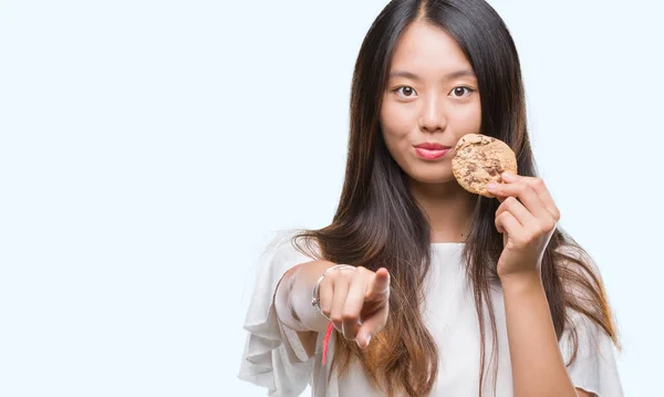 Joven Mujer Asiática Comiendo Galletas Chocolate Sobre Fondo Aislado Señalando — Foto de Stock