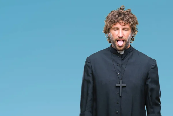 Hezký Hispánský Katolický Kněz Muž Nad Izolované Pozadí Držet Jazyk — Stock fotografie