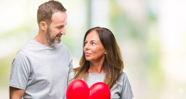 Medelåldern Spansktalande Casual Par Kärlek Hålla Rött Hjärta Över Isolerade — Stockfoto