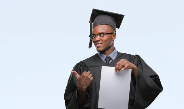 Молодой Афроамериканец Дипломом Бакалавра Изолированном Фоне Показывает Пальцем Вверх Сторону — стоковое фото