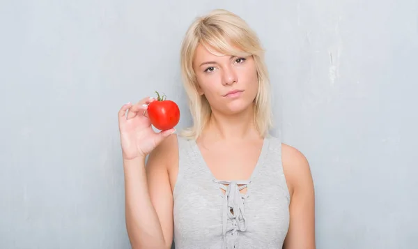 Mujer Caucásica Adulta Sobre Pared Gris Grunge Sosteniendo Tomate Fresco —  Fotos de Stock