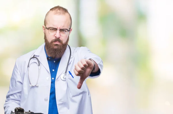 年轻的医生拿着剪贴板在孤立的背景与愤怒的脸 显示不喜欢大拇指的负面标志 拒绝的概念 — 图库照片
