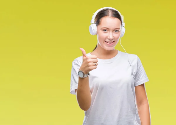 Joven Mujer Caucásica Escuchando Música Usando Auriculares Sobre Fondo Aislado —  Fotos de Stock