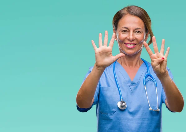 中年资深护士医生妇女在孤立的背景显示和指向手指数字九 而微笑着自信和快乐 — 图库照片