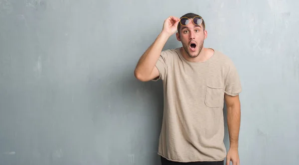 Joven Caucásico Hombre Sobre Gris Grunge Pared Usando Gafas Sol — Foto de Stock