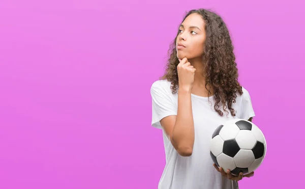 Mujer Hispana Joven Sosteniendo Pelota Fútbol Cara Seria Pensando Pregunta —  Fotos de Stock