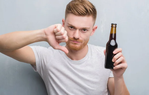 Jovem Ruivo Sobre Parede Grunge Cinza Bebendo Garrafa Cerveja Com — Fotografia de Stock