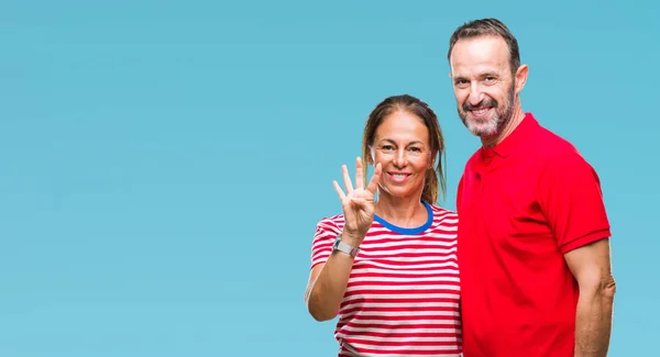 中年拉美裔夫妇在爱在孤立的背景显示和指向手指四 而微笑着自信和快乐 — 图库照片