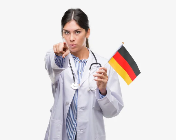 Joven Doctora Hispana Sosteniendo Bandera Alemania Señalando Con Dedo Cámara —  Fotos de Stock