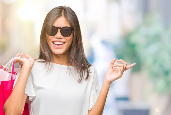 側の手と指で指す非常に幸せな孤立の背景の上ショッピング バッグを持つ販売若いアジア女性 — ストック写真