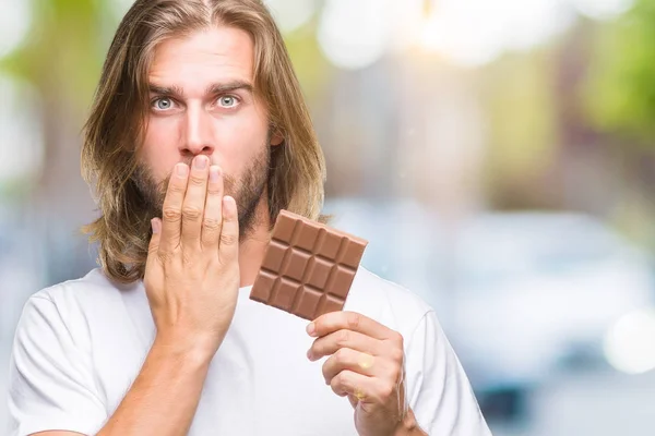 Joven Hombre Guapo Con Pelo Largo Comer Barra Chocolate Sobre — Foto de Stock