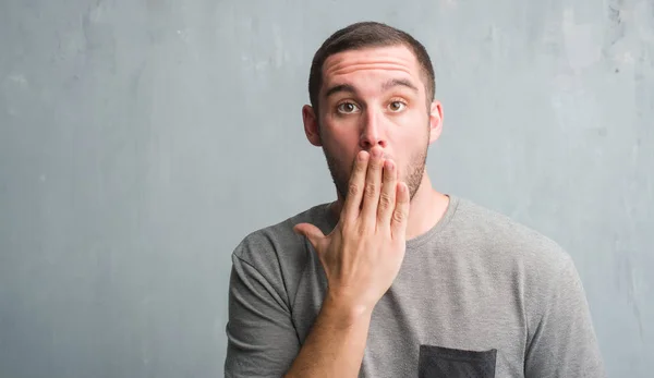 Joven Caucásico Hombre Sobre Gris Grunge Pared Cubrir Boca Con —  Fotos de Stock