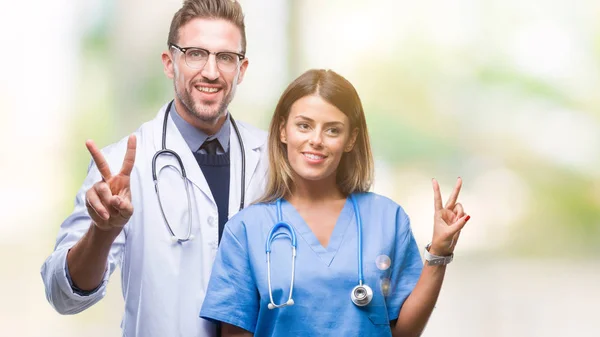 Pareja Joven Médico Cirujano Sobre Fondo Aislado Sonriendo Con Cara —  Fotos de Stock