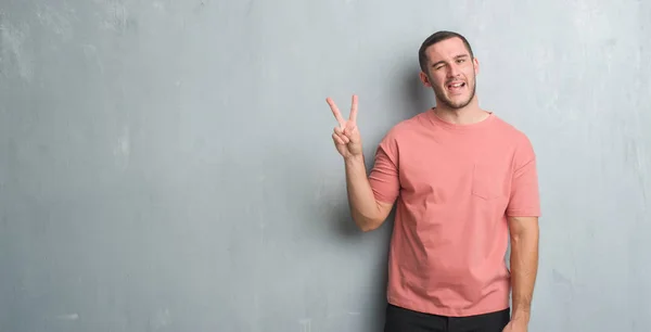 Joven Hombre Caucásico Sobre Pared Gris Grunge Sonriendo Con Cara —  Fotos de Stock