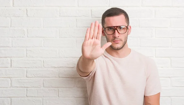 Joven Hombre Caucásico Pie Sobre Pared Ladrillo Blanco Con Gafas —  Fotos de Stock