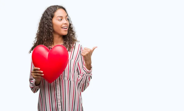 Jovem Hispânica Apaixonada Segurando Coração Vermelho Apontando Mostrando Com Polegar — Fotografia de Stock