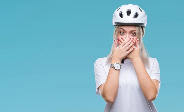 年轻的金发女子戴着骑自行车的安全头盔在孤立的背景震惊地覆盖口与手错误 秘密概念 — 图库照片