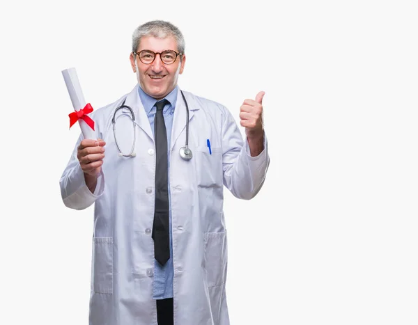 英俊的高级医生男子持有学位论文在孤立的背景指向和显示与拇指面带笑脸微笑 — 图库照片