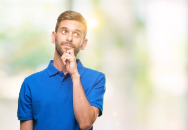 Yakışıklı delikanlı çene düşünme hakkında soru, dalgın ifade üzerine el ile izole arka plan üzerinde. Düşünceli yüzüyle gülümsüyor. Şüphe kavramı.