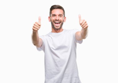 Yakışıklı delikanlı el ile pozitif jest yapıyor onaylama izole arka plan üzerinde başparmak gülümseyen ve başarı için mutlu. Kamera, kazanan jest arıyorsunuz.