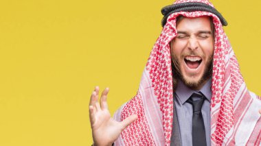 Uzun saçlı keffiyeh üzerinde giyen genç yakışıklı Arap adam arka plan deli kutluyor izole ve crazy arms ile başarı için kaldırdı ve heyecanlı çığlık gözler kapalı. Kazanan kavramı