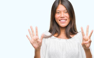 Genç Asyalı kadın gösterilen ve parmakları ile işaret izole arka plan üzerinde kendinden emin ve mutlu gülümseyerek süre sekiz numara.