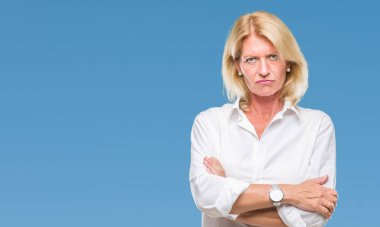 Orta yaş sarışın iş kadın izole arka plan şüpheci ve çapraz kolları olan yüzündeki gergin, onaylamayan ifade yüzünden. Negatif kişi.