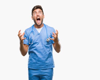 Genç yakışıklı Doktor cerrah adam izole arka plan çılgın ve kızgın bağırarak ve agresif ifade ve silah kaldırdı bağırıyor. Hayal kırıklığı kavramı.