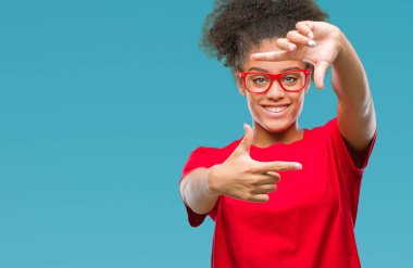 Elle yapma çerçeve ve parmakları ile mutlu yüz gülümseyen izole arka plan üzerinde gözlük takan genç afro Amerikalı kadın. Yaratıcılık ve Fotoğrafçılık kavramı.