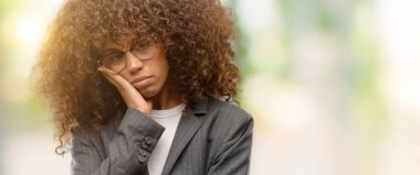 Seyir yorgun ve çapraz kolları olan depresyon sorunları ile sıkılmış düşünme gözlük takan Afrikalı-Amerikalı iş kadını.